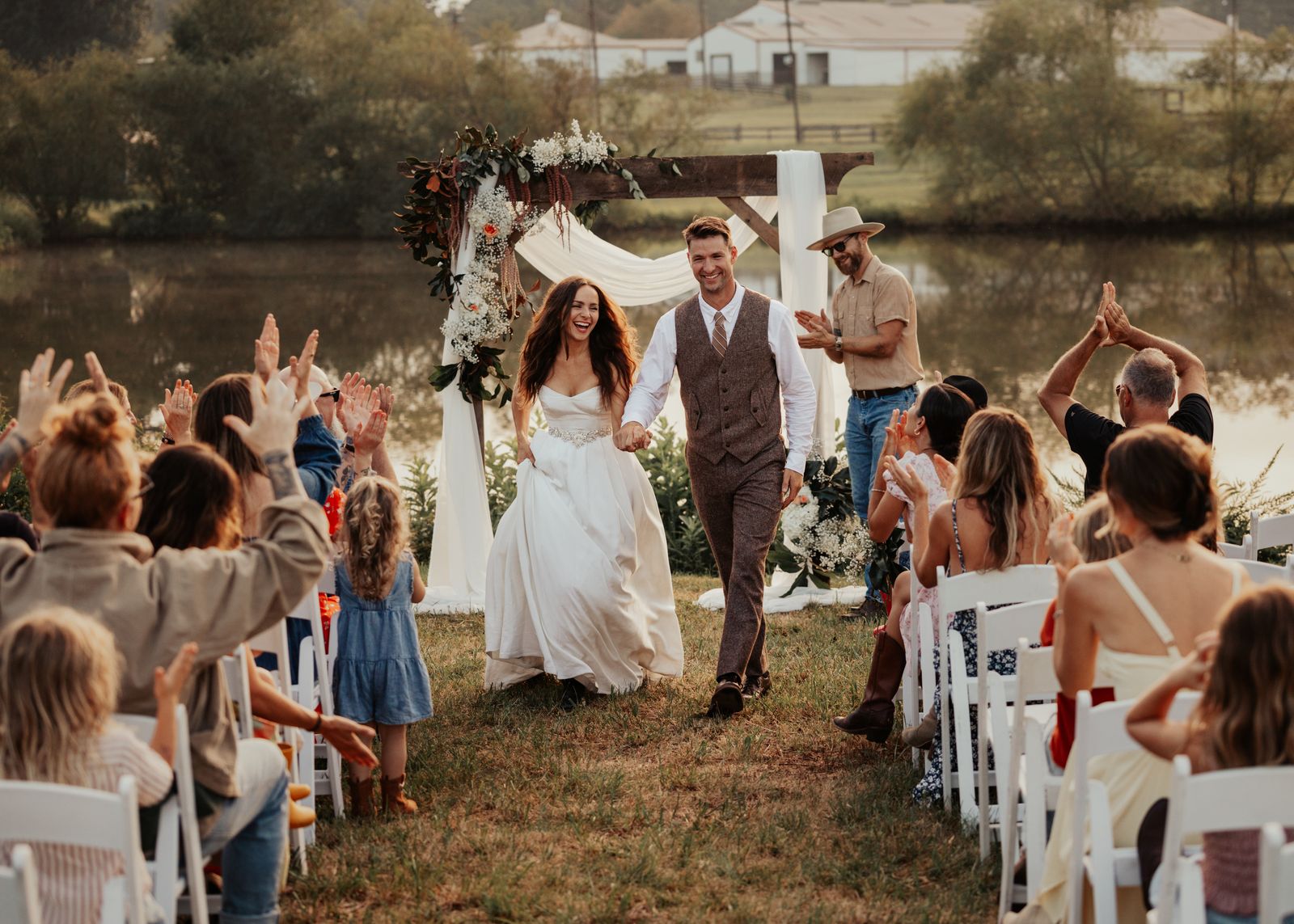 Newlyweds walking back up the aisle with guests celebrating