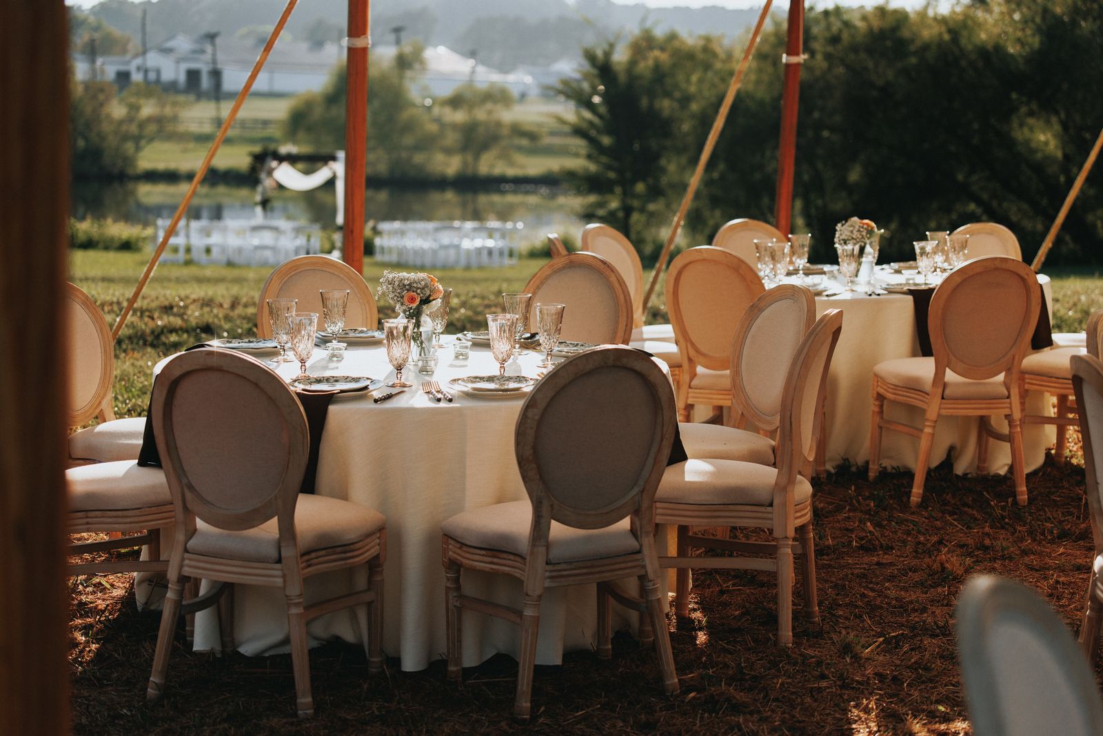 Reception tables set with linens under the tent